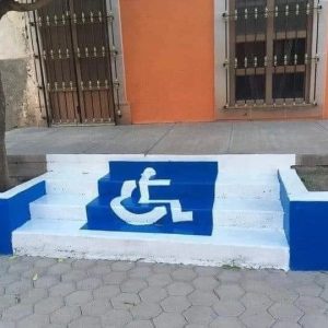 wheelchair sign in blue painted on white steps