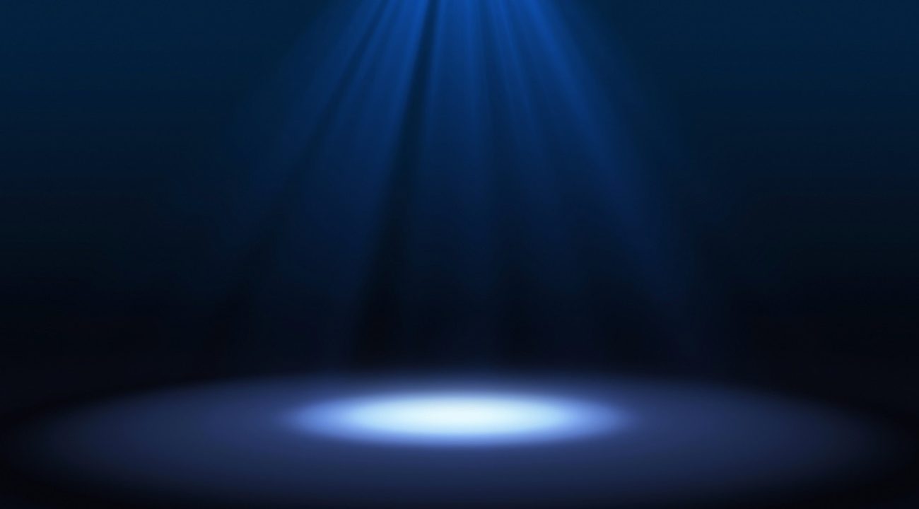 Blue spotlight on stage performance in a theater